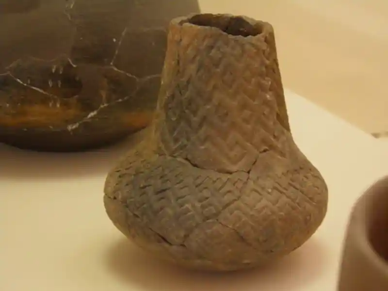 Cross from zigzig pattern and connected diamonds engraved on a clay vase